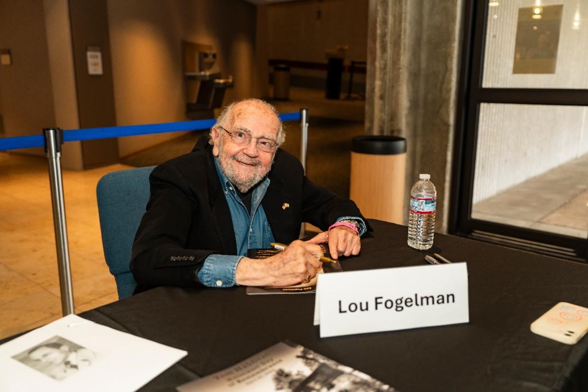 Lou Fogelman sitting at his signing table.