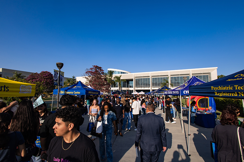 Students walking, looking at booths on campus