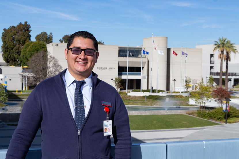 Kevin Crisanto poses by Cypress College fountain