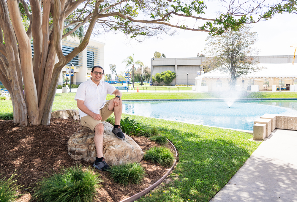 Alumus Theodore Abdelmaseh sits by the Cypress College pond.